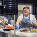 En ung kvinna som jobbar i delidisken på en stormarknad.