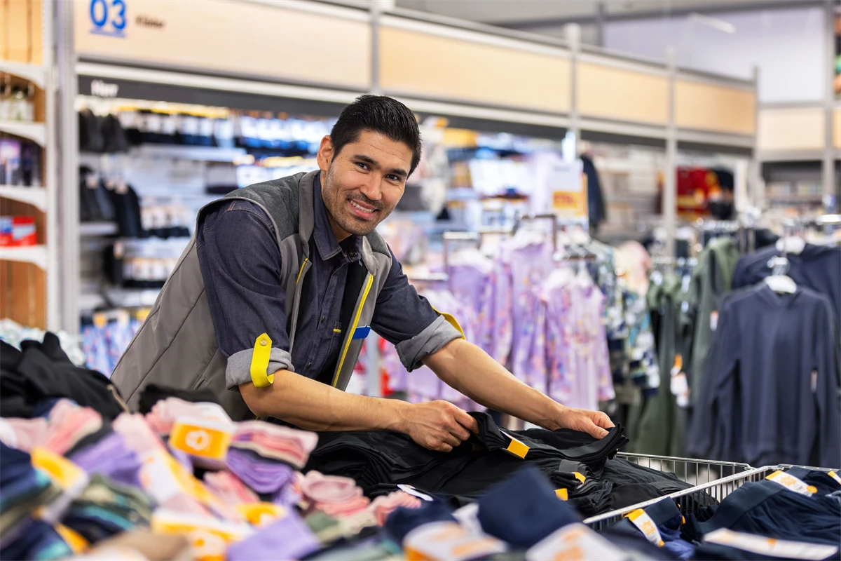 En man som jobbar på klädavdelningen på en stormarknad.