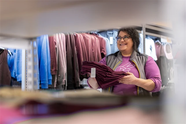 En kvinna som jobbar på klädavdelningen på en stormarknad.