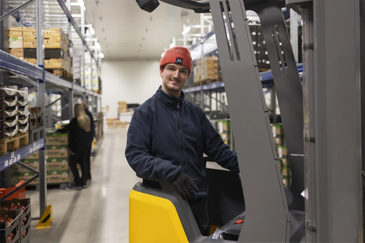 Ung manlig truckförare på ett lager