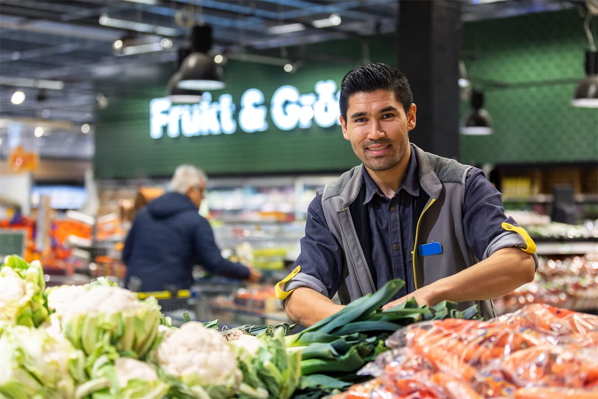 En man som jobbar i frukt- & gröntavdelningen på en stormarknad.