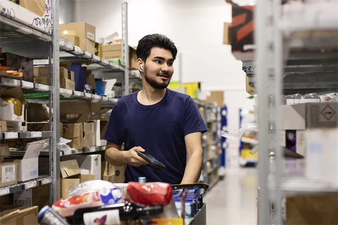 Ung man som jobbar på lager.