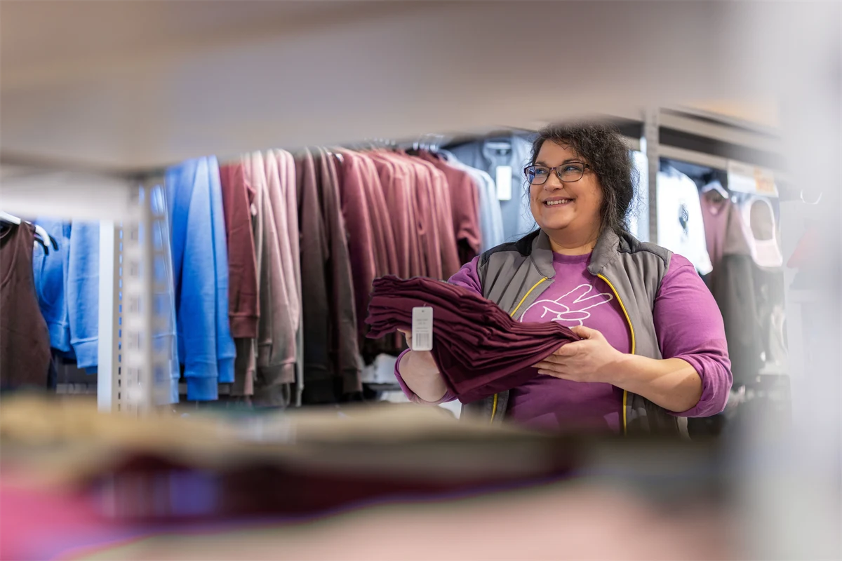 En kvinna som jobbar på klädavdelningen på en stormarknad.